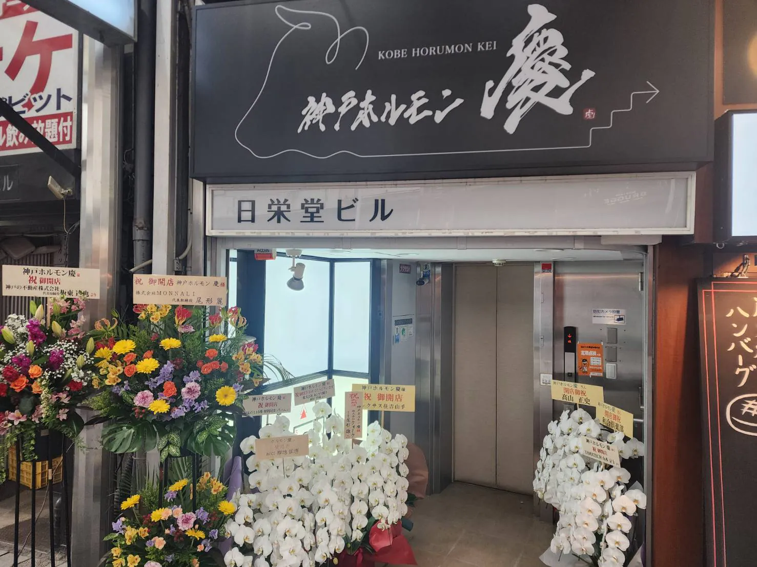 開店祝いの花が並ぶ神戸ホルモン 慶の入口